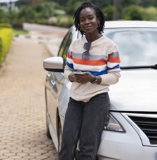 portrait-young-woman-with-afro-dreadlocks-posing-with-car